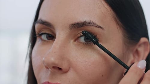 Woman Applies Mascara in Close Up Beauty Shot