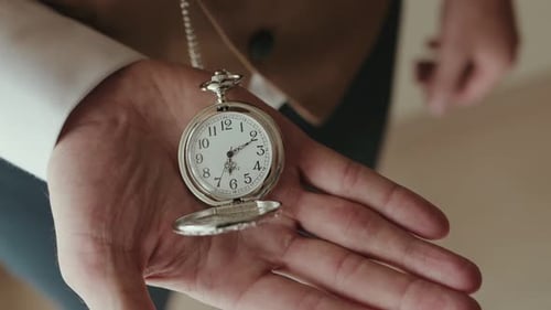 Man's Hand Holding Silver Pocket Watch