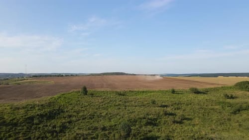 Aerial View of Tractor Plowing Agriculural Farm Field Preparing Soil for Seeding in Summer