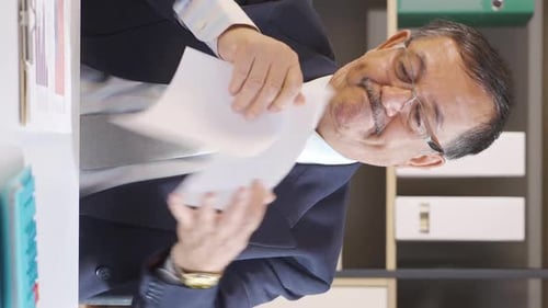 Businessman Rips Paper at Office Desk