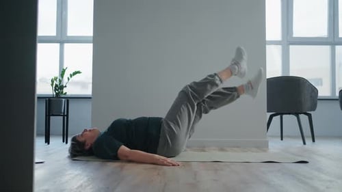 Woman Doing Leg Raises on Yoga Mat Indoors