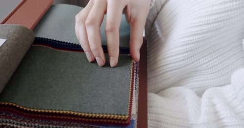 Closeup of Female Hands Choosing Fabric From Color Palette at Textile Showroom