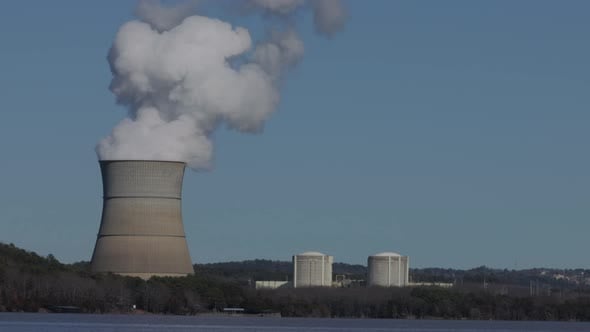 Nuclear stack emitting steam in real time on a sunny and cloudless day ...