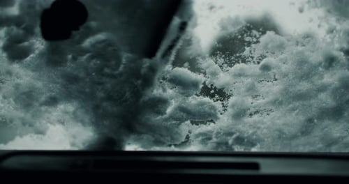 Autoscheibenwischer entfernen starken Schnee von Glasfenstern mit Bürstenblättern. Fahrzeuginnenraum