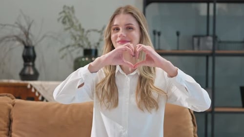 Woman Makes Heart Shape with Hands