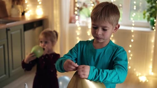 Children Blowing Up Balloons at Birthday Party