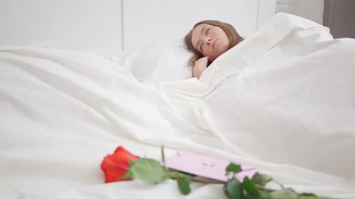 Woman Awakes to Rose and Letter Gift in Bed