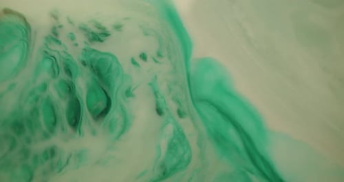 Close up, top down view of green and white ink experiment looks like giant gas cloud in space explod