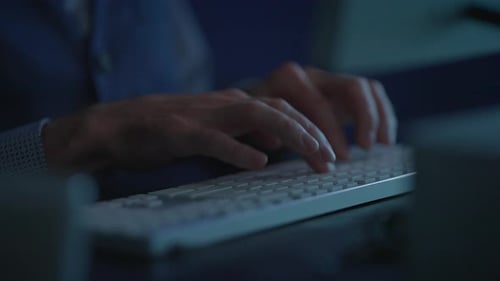 Hands Typing On A Keyboard At Night