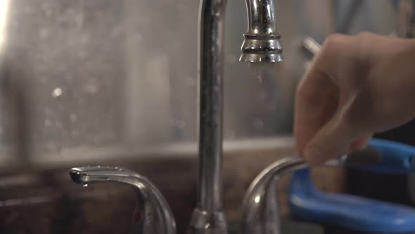 Turning On The Water From The Faucet In The Kitchen Sink. close up shot ...