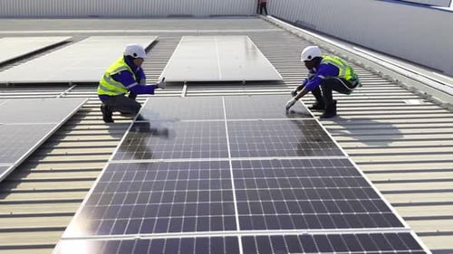 Technician installing solar cell. Installation and maintenance of solar cells on rooftop.