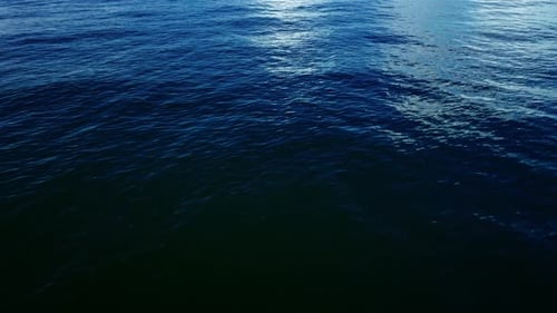 Luftaufnahme von oben auf ein transparentes blaues Meer mit schönen Wellen an sonnigen Tagen im Sommer. Meeresluft