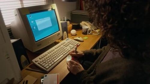 Frau markiert Disketten, um Dateien zu speichern, während sie an einem Vintage-Computer arbeitet