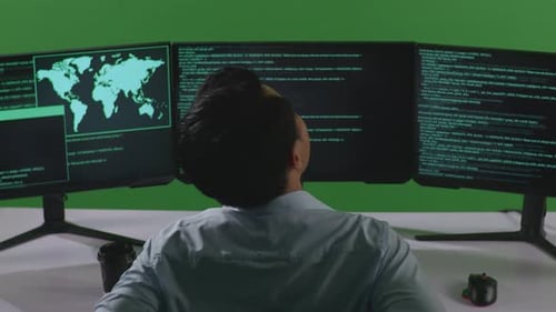 Asiatischer Mann hat Rückenschmerzen beim Schreiben von Code mit mehreren Computerbildschirmen auf grünem Bildschirm