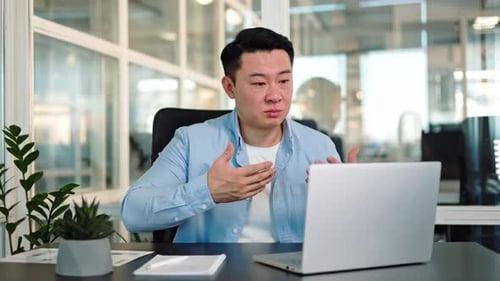 Young Man in Office Attends Video Meeting