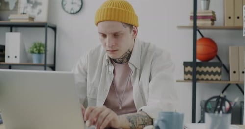 Portrait of Exhausted Office Worker Using Laptop Typing Then Touching Head Feeling Headache