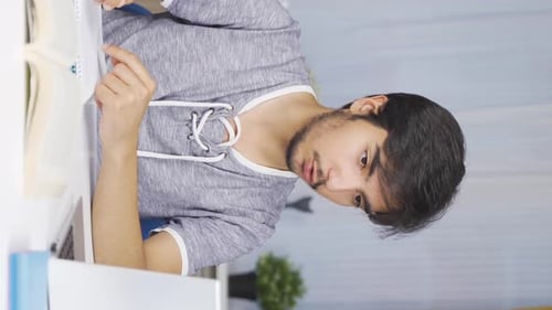 Young Adult Studying at Desk with Books