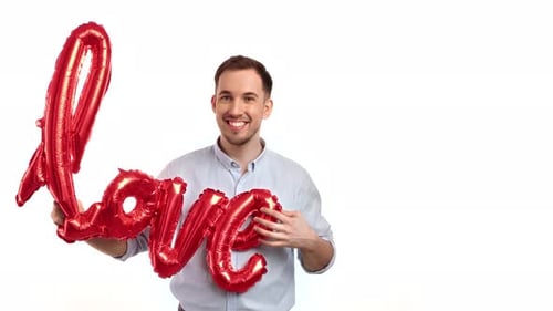 Man Holding Red 'Love' Balloon Smiling