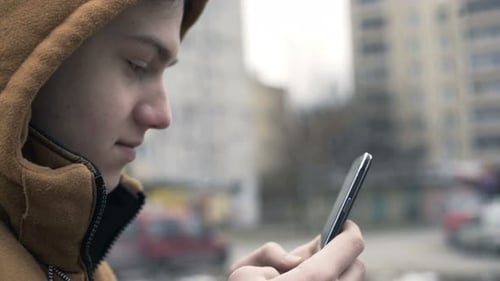 Teenager Surfing Internet, Texting On Smartphone In The City