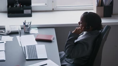 Female Operator Typing on Laptop Keypad while Consulting Online Client