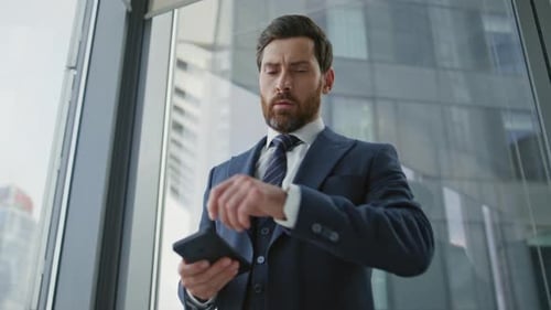 Serious bearded company manager unsatisfied phone call in modern office close up