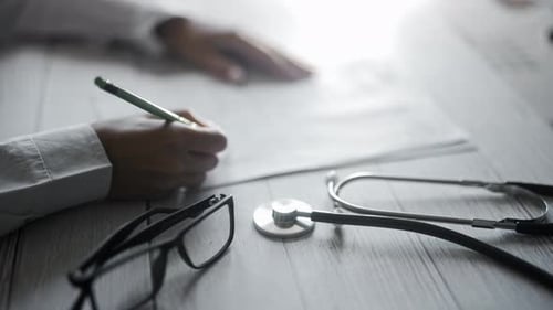 A Doctor is Writing Notes on Medical Examination or Prescribing Treatment in Health Clinic Physician