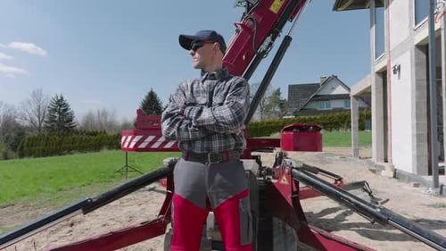 Un travailleur sur un chantier de construction conduit une grue à fenêtres lourde en mettant l'accent sur la sécurité et la précision