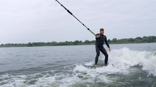 Man wake surfing on lake, water sports activity