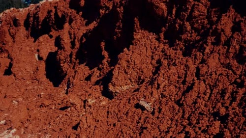 Excavator Filling Dump Trucks at a Rural Clay Pit
