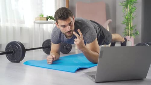 Man Does Plank and Watches Laptop at Home