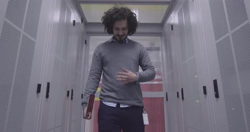 Man Walks Through Modern Data Center Corridor