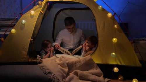Father Reads Book to Children in Cozy Tent