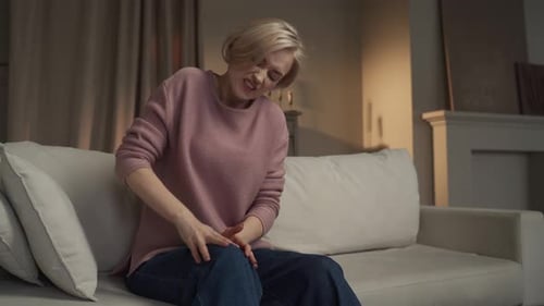 Woman Massaging Knee in Discomfort