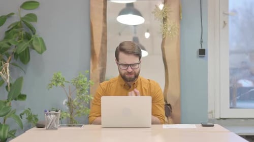 Man Working on Laptop at Desk Indoors