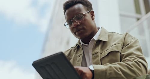 Young Adult Working on Tablet in the City