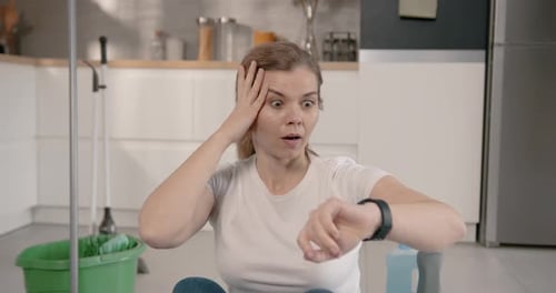 Woman Shocked at Watch While Cleaning Kitchen