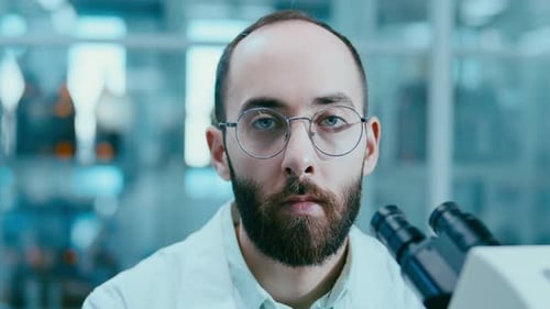 Portrait of Professional Scientist with Microscope at Research Center