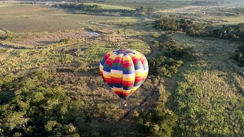 Colorful Hot Air Balloon Flying Over Rural Landscape