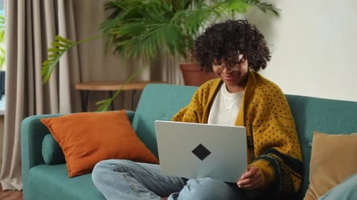 African American Girl Using Laptop at Home Office Looking at Screen Typing Chatting Reading Writing