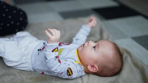 Adorable Infant Lying on Blanket Indoors