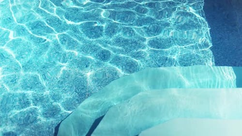 The Clear Water in the Pool Gleams and Reflects the Rays of the Sun on a Summer Day