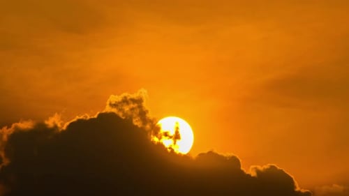Sun Emerges from Behind Clouds in Time Lapse
