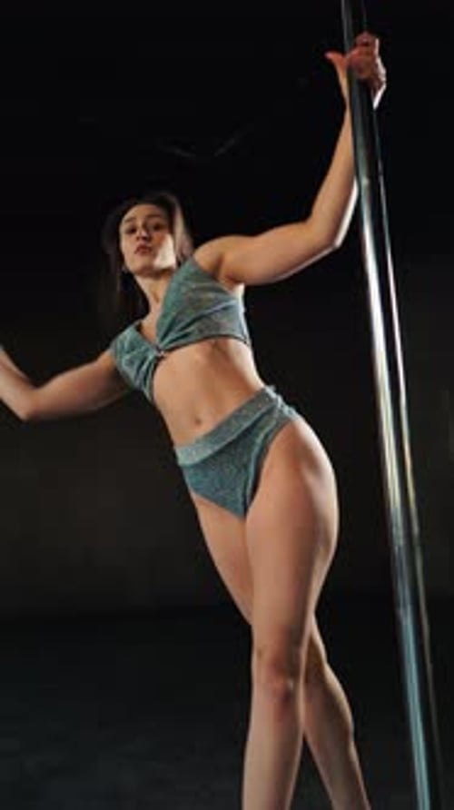 Woman Performing Pole Dance Routine in Studio
