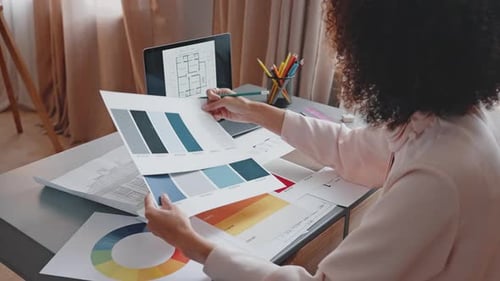 African American Woman Compares Colors for Interior Design