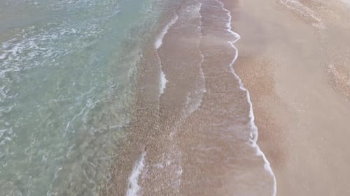 Turquoise Waves Gently Lapping on a Sandy Beach