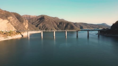 Aerial drone flying over a lake, water dam, with mountains at sunrise. Beautifull dreamy landscape v