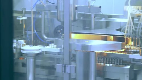 Pharmaceutical manufacturing machine producing medical ampoules at factory plant