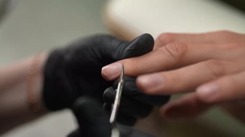 Gloved Hand Manicuring Cuticle With Scissors
