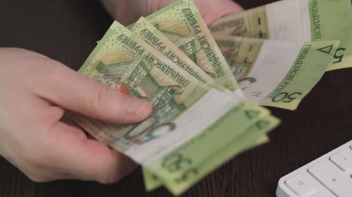 Employee Meticulously Counts Rubles Amidst Busy Work Environment Focused Individual Counts Currency