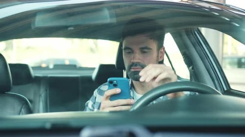 Man in Car Using Mobile Phone